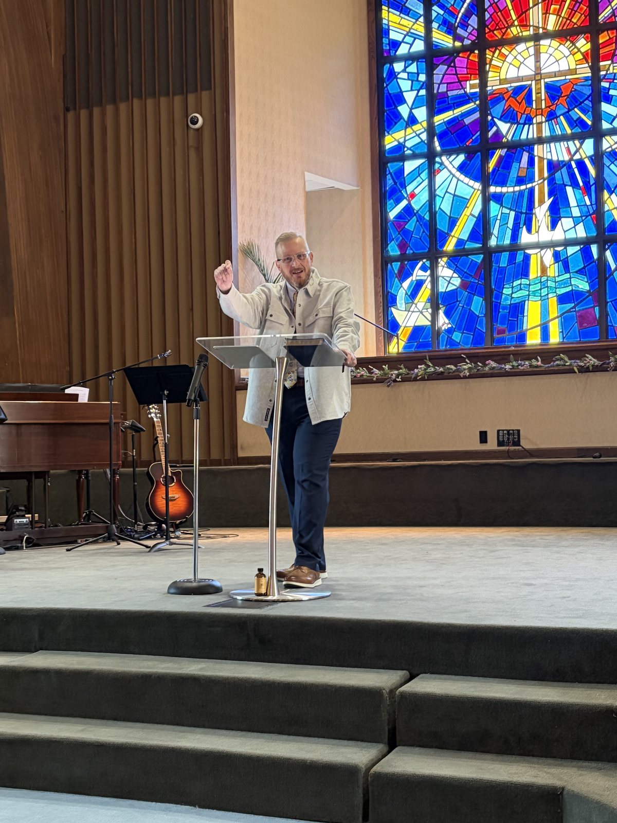 Pastor David Crawford preaching at GT Church beneath the stained glass